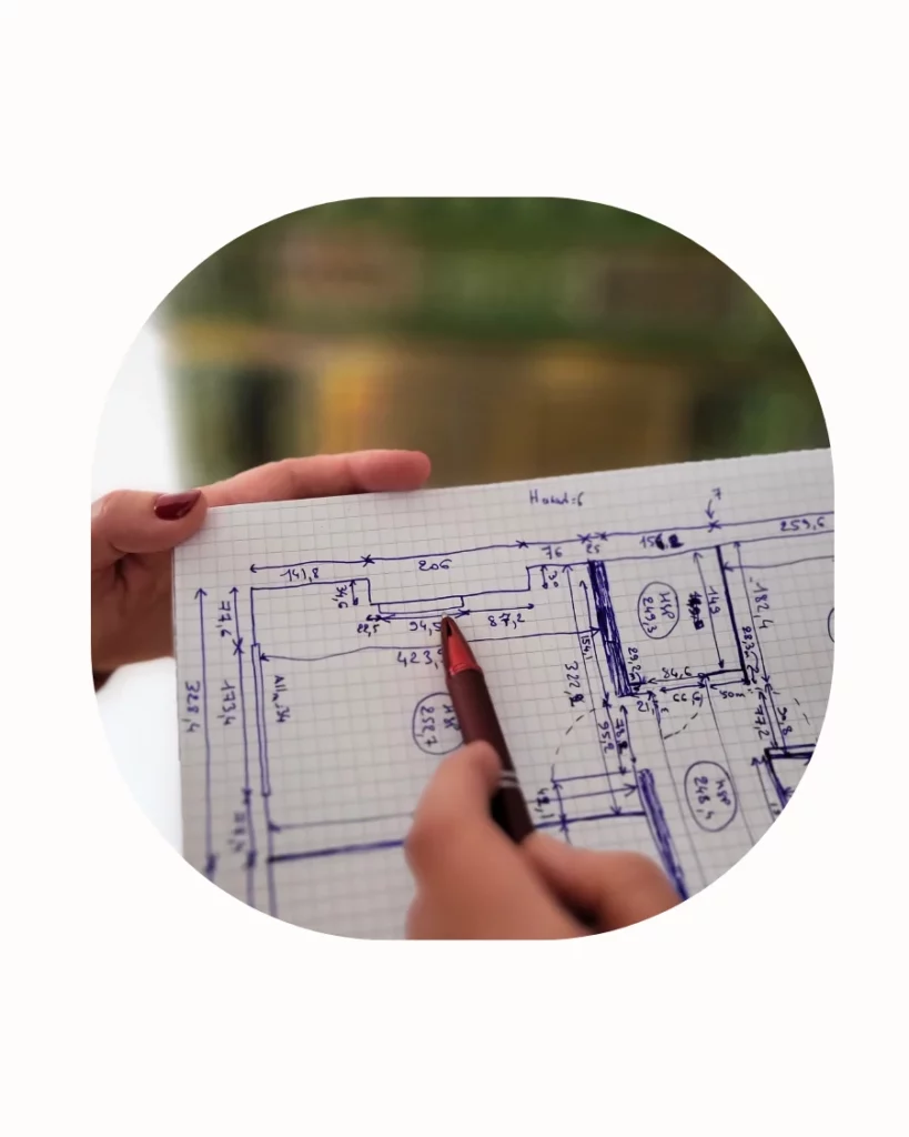 Plan à main levée d’un projet d’aménagement intérieur avec main pointant une contrainte technique